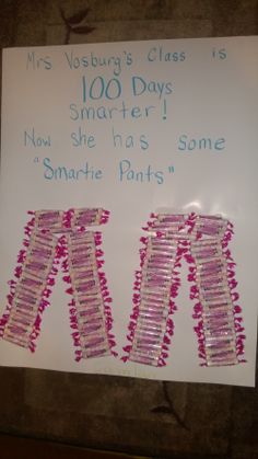 a white sign with pink and red pins on it that says, mrs vosby's class is 100 days smarter now she has some smart pants