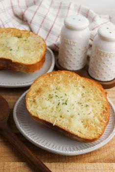 two slices of garlic bread sitting on top of white plates