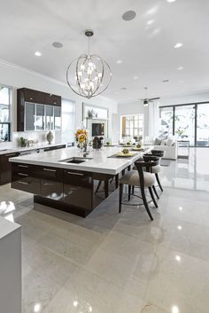 a large kitchen with white counter tops and black cabinets