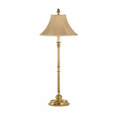 a gold lamp with a beige shade on it's base and a white background