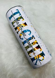 a can with the word happy on it sitting on a white fur covered floor next to an umbrella