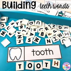 a blue tray filled with lots of cut out letters and words that spell building teeth