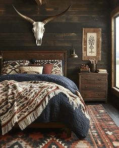 a bed room with a neatly made bed and a cow skull on the wall