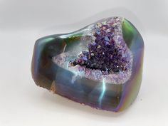 a purple and green piece of rock sitting on top of a white table