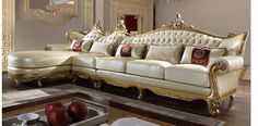 a living room filled with furniture on top of a hard wood floor covered in white and gold