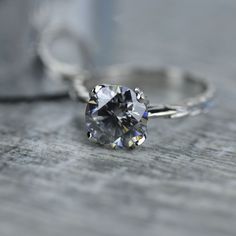 a diamond ring sitting on top of a wooden table