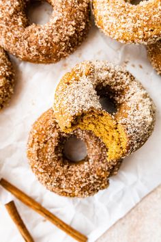 there are many donuts on the table with cinnamon sticks