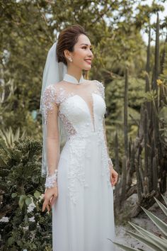 a woman in a wedding dress standing next to cactus