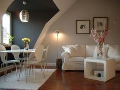 a living room filled with white furniture and lots of windows on top of the walls