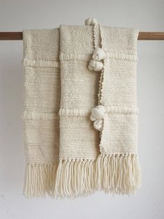 two white towels hanging on a wooden rack