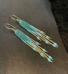 "Maui Swan Designs beautiful, delicate earrings. Czech glass seed beads hand sewn with nylon thread, 3\" long, 3/8\" wide. Original design, incorporates iridescent, opaque and transparent seed beads. Beautiful & bold tones of dark teal, turquoise and gold. Handmade 14K gold-filled clasp. These are stunning & tiny enough u won't feel them on your ears but they are super shiny!!" Handmade Gold Beaded Long Drop Earrings, Chain Fringe, Sea Sand, Turquoise And Gold, Teal Turquoise, Wire Wrapped Earrings, Delicate Earrings, Seed Bead Earrings, Dark Teal