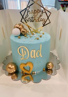 a blue and gold birthday cake with the word dad written on it's side