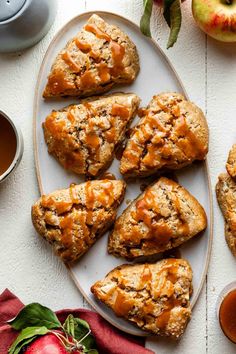 apple scones on a white plate with apples and sauces next to the tray