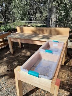 two plastic containers sitting on top of a wooden bench next to a table with benches