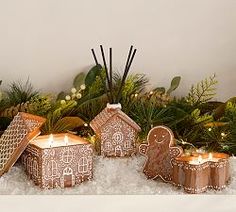 gingerbread house candles are sitting in the snow