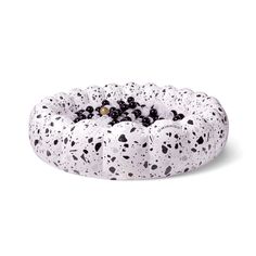 a black and white cake with sprinkles on it's top is sitting in front of a white background