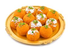 a plate filled with oranges covered in powdered sugar and garnished with green leaves