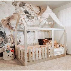 a child's bedroom with a white canopy bed and floral wallpaper on the walls