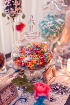 there are many candies in the glass vases on the table with other candy