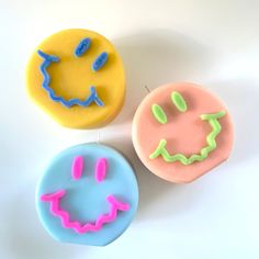 three decorated donuts sitting next to each other on top of a white countertop