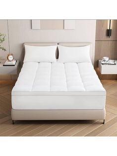 a bed with white sheets and pillows in a room