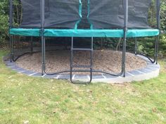 an empty trampoline sitting in the middle of a yard