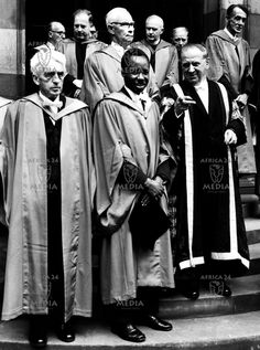 a group of men standing on steps in front of a building wearing robes and stoles