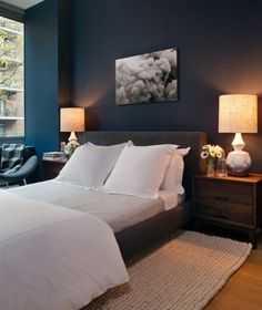 a bedroom with blue walls and white bedding