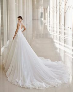 a woman in a white wedding dress is posing for the camera