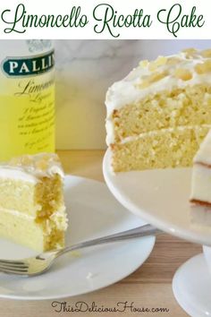 a slice of lemon ricotta cake on a white plate with a fork and bottle in the background