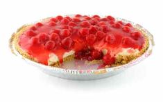 a pie with cherries on top is in a tin foil dish, ready to be eaten