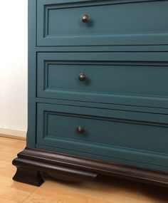 a blue dresser with three drawers on top of it