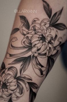 a black and white flower tattoo on the arm