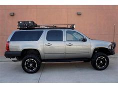 a silver truck parked in front of a building with its roof rack mounted on it's flatbed