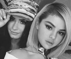 two beautiful young women wearing hats posing for the camera