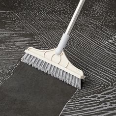 a white broom on top of a black floor