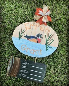 a wooden sign sitting on top of a lush green grass covered field next to a plaque