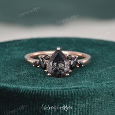 an engagement ring with two pear shaped black diamonds