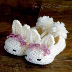 crocheted slippers with bunny ears and pink bows on the bottom, sitting on a wooden floor