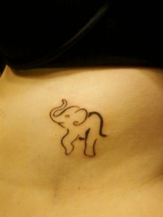 a small elephant tattoo on the side of a woman's lower back stomach,