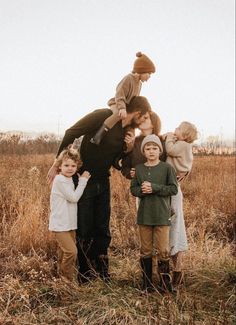 a group of people standing in a field with one person on top of the other