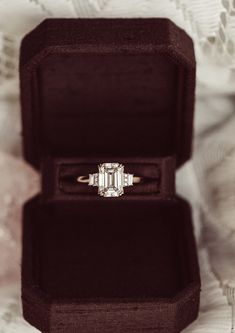 an engagement ring sitting in a velvet box