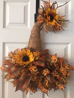 a sunflower and burlock wreath hanging on the front door to welcome guests