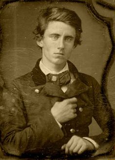 an old black and white photo of a man in a suit with a bow tie