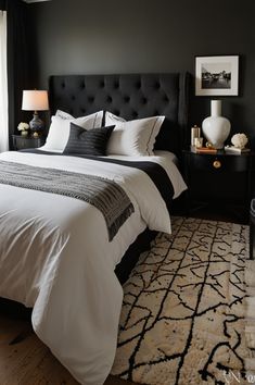 a black and white bedroom with a large bed in the corner, two lamps on either side