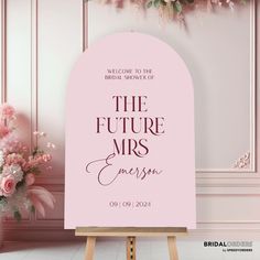 a pink sign that says the future mrs and mr on it with flowers behind it