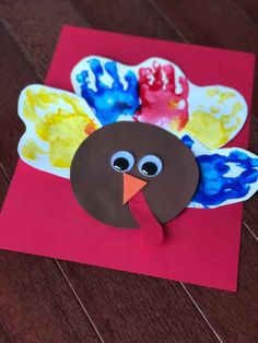 a paper turkey on top of a red envelope