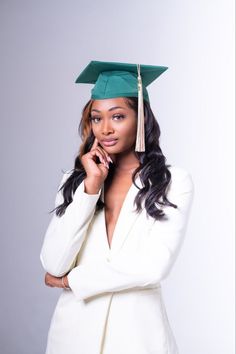 a woman in a graduation cap and gown posing for the camera with her hand on her chin