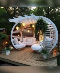 an outdoor living area with white furniture and potted plants on the wooden decking