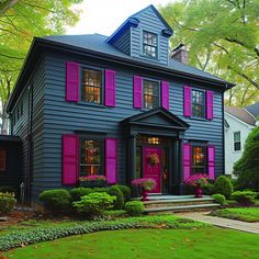 a blue house with pink shutters and green grass